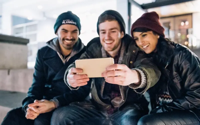 Amigos com celular e câmera