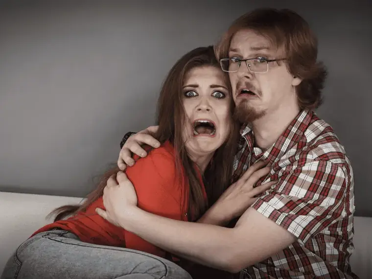 Casal assustado assistindo a um filme