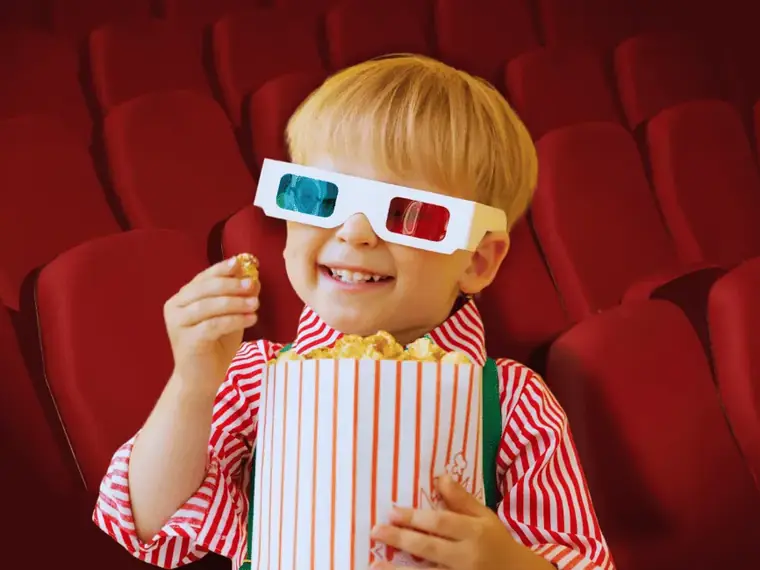 Criança com óculos 3D e pipoca