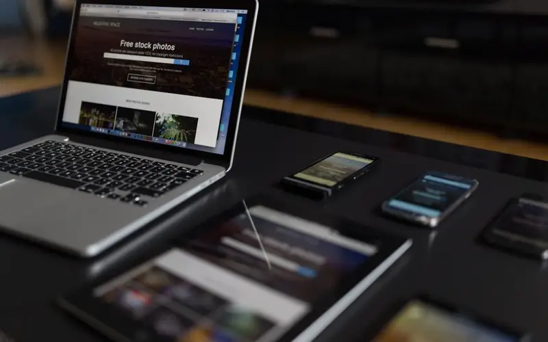 Notebook e tablets sobre uma mesa escura